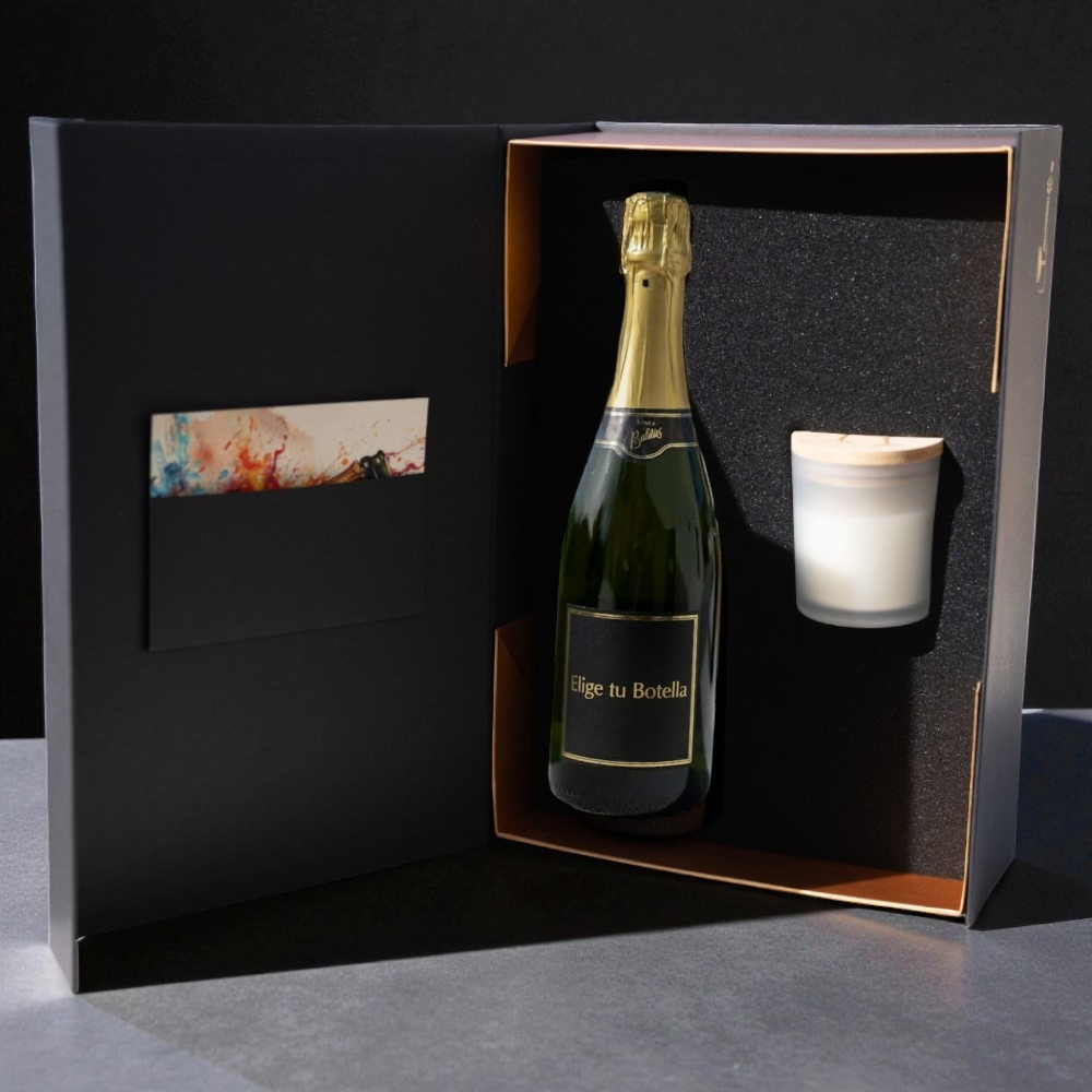 Caja de regalo elegante con una botella de cava y una vela aromática en su interior.